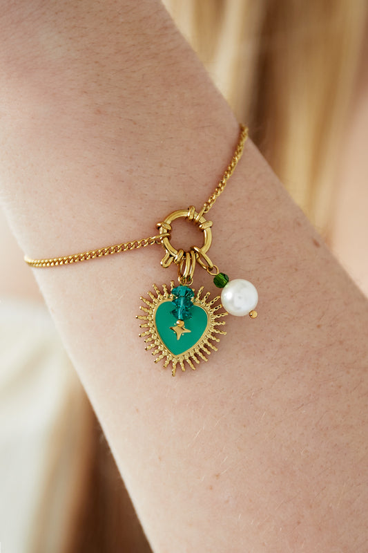 Golden charm bracelet with radiant green heart